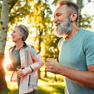 A man and woman running in the woods, representing summer routine and healthier habits