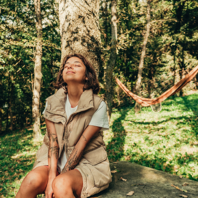 Self-care essentials: a practical guide for supporting your patients 7 A woman sitting on a rock in front of a hammock, representing self-care