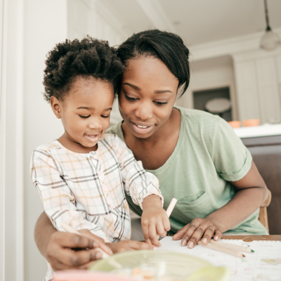 A woman and child drawing, representing parenting and mental health